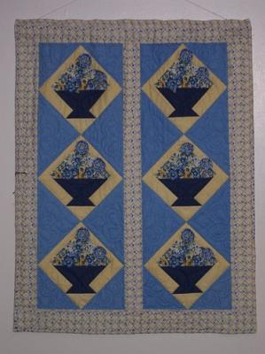 This wall hanging was made from an Elenor Burns pattern and 3D flowers are sewn on with sead beads .Top & backing are constructed using quality 100% cotton, batting is low loft polyester. Machine pieced and machine quilted by Linda Monasky.
