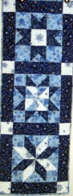 3 different star patterns give this table runner more interest.All fabrics are quality 100% cotton winter prints. Machine pieced and machine quilted by Linda Monasky.<br />