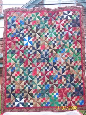 This queen sized quilt was made to be displayed on a log bed. Top is constructed using Home Spun and solid cottons. It has double layer of high loft batting and a red & black buffalo checked flannel backing. It was machine pieced and machine quilted by Linda Monasky. 