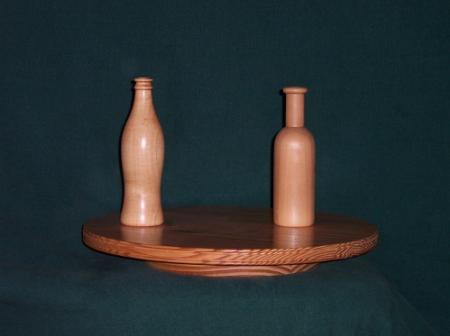 Wooden bottles are turned on a wood lathe in various sizes,wood varieties and shapes. 15" round lazy susan is made from yellow pine previously used for school bleachers.