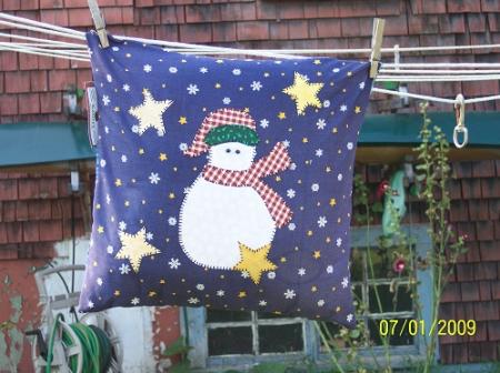 The front of this pillow is appliqued snowman and stars. Filled with polyester.Made by Linda Monasky